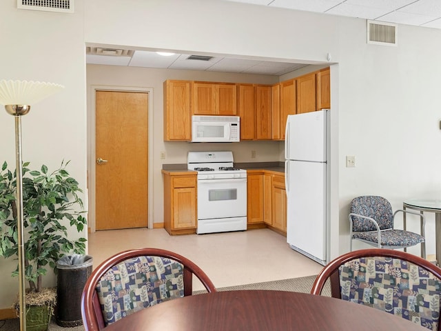 kitchen featuring white appliances and a paneled ceiling