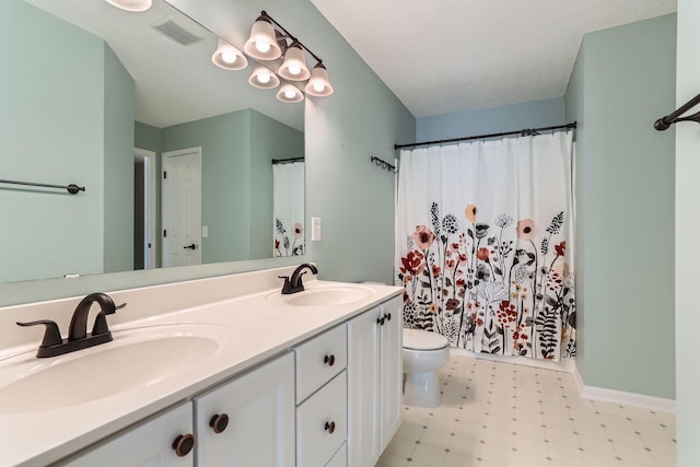 bathroom featuring toilet, a sink, visible vents, and tile patterned floors