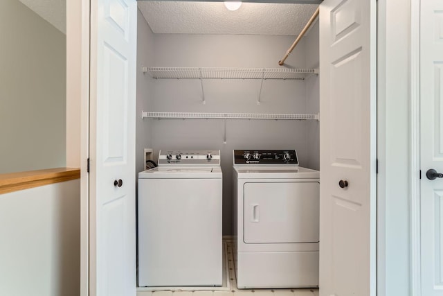 washroom with washer and dryer, laundry area, and a textured ceiling