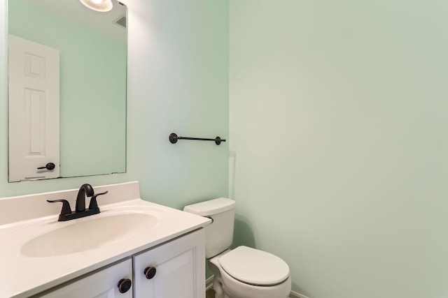 bathroom with visible vents, vanity, and toilet