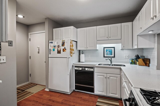 7500 Cahill Rd Unit 207C, Edina, MN 55439 - kitchen with freestanding refrigerator, black dishwasher, stove, light countertops, and wood finished floors