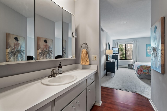 7500 Cahill Rd Unit 207C, Edina, MN 55439 - bathroom with vanity, wood finished floors, ensuite bathroom, and baseboards