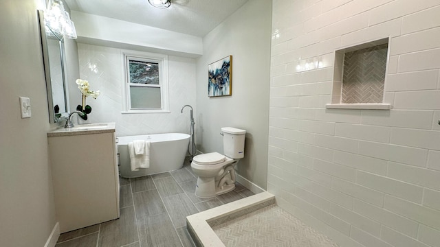 bathroom featuring vanity, a bath, and toilet