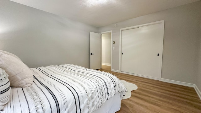 bedroom with hardwood / wood-style floors and a closet