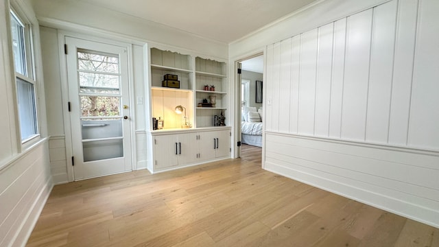 mudroom with ornamental molding and light wood-type flooring