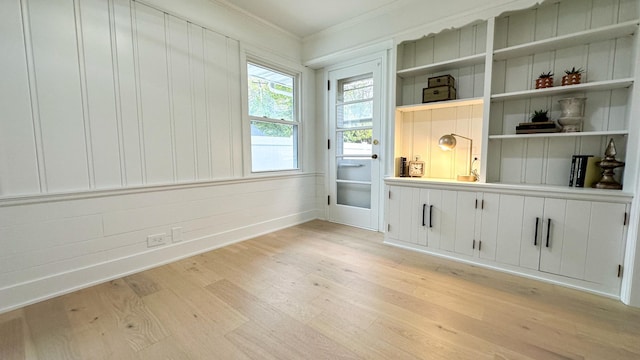 interior space with ornamental molding and light wood-type flooring