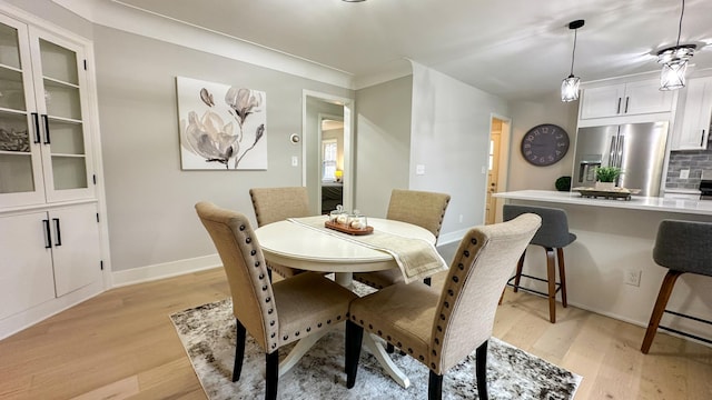 dining area featuring light hardwood / wood-style floors and crown molding