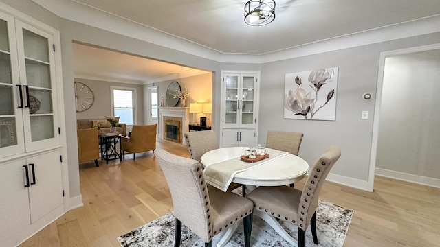 dining area featuring light hardwood / wood-style floors and crown molding