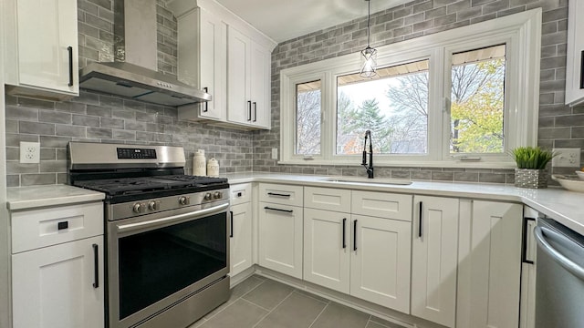 kitchen with white cabinetry, wall chimney range hood, backsplash, and appliances with stainless steel finishes