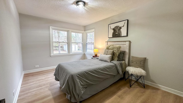 bedroom featuring a textured ceiling and light hardwood / wood-style floors