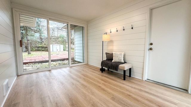 interior space featuring wood walls, light hardwood / wood-style floors, and a wealth of natural light