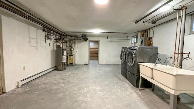 basement featuring water heater, a baseboard radiator, and independent washer and dryer