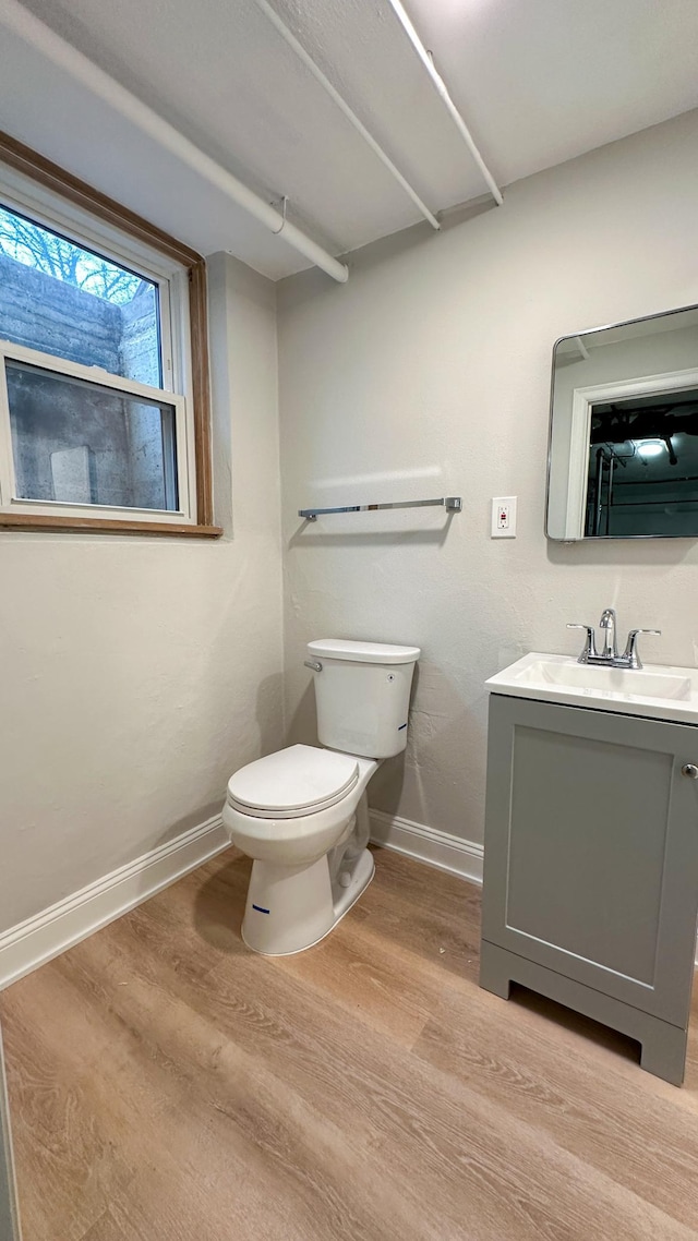 bathroom with vanity, toilet, and wood-type flooring