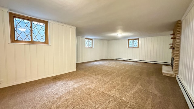 basement featuring dark carpet, a wealth of natural light, and a baseboard radiator