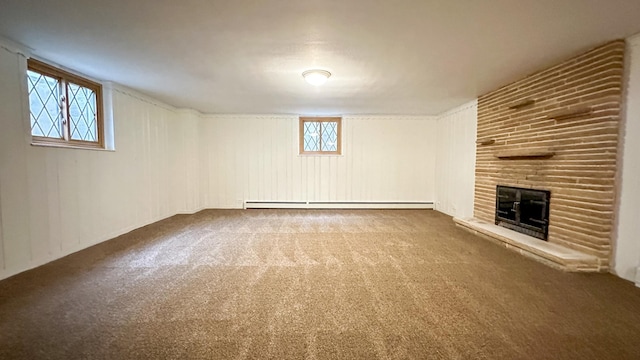 basement with baseboard heating, carpet, and a brick fireplace