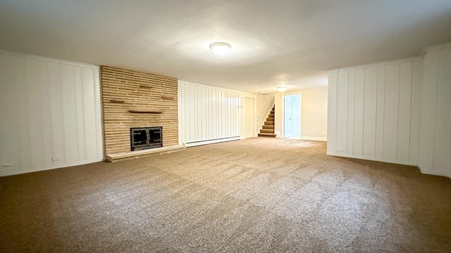 unfurnished living room with carpet flooring, baseboard heating, and a fireplace