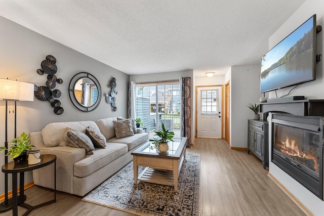 living room with light hardwood / wood-style floors and a textured ceiling