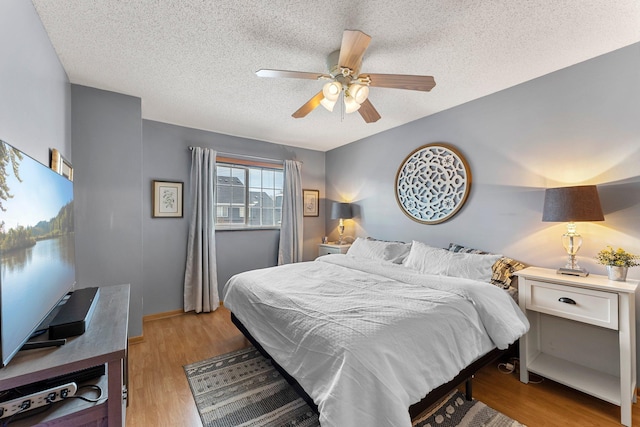 bedroom featuring a textured ceiling, light hardwood / wood-style flooring, and ceiling fan