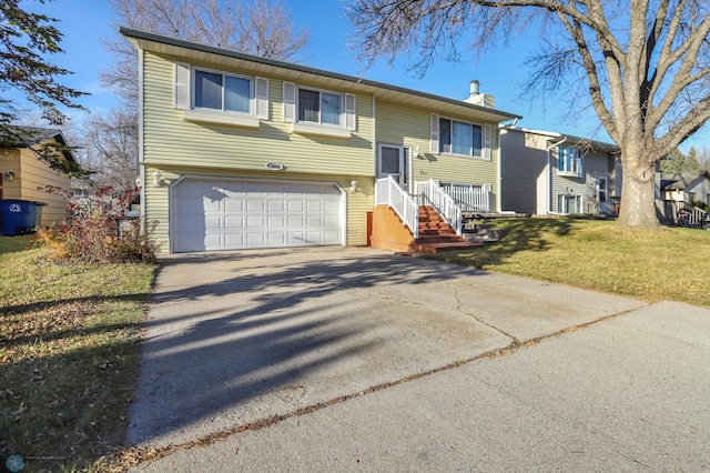 bi-level home with a garage and a front lawn