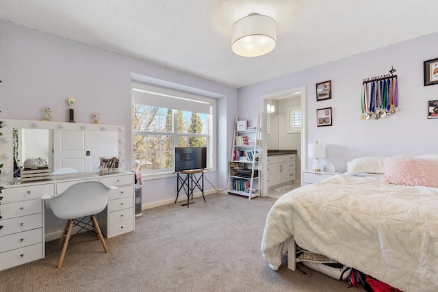 bedroom featuring ensuite bathroom and light colored carpet