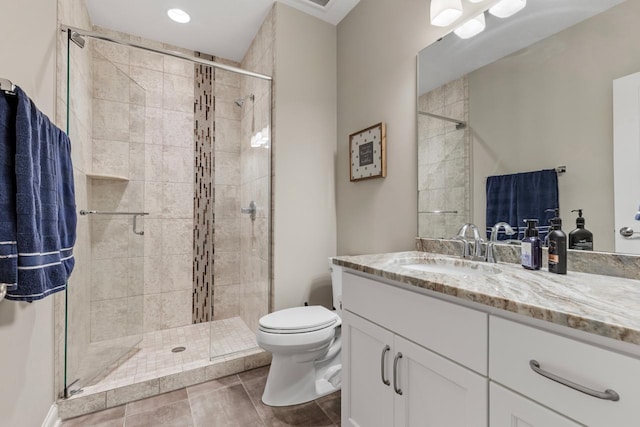 bathroom with toilet, vanity, tile patterned flooring, and walk in shower