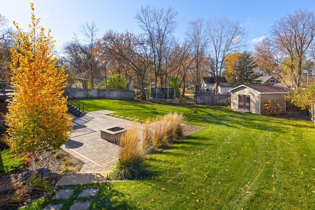 view of yard featuring a shed, a trampoline, and a patio area