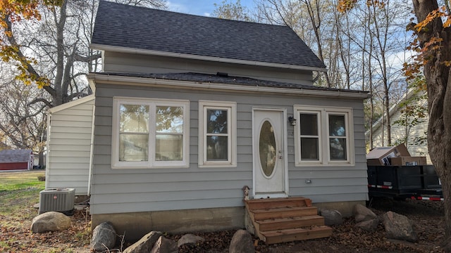 bungalow-style home with central air condition unit