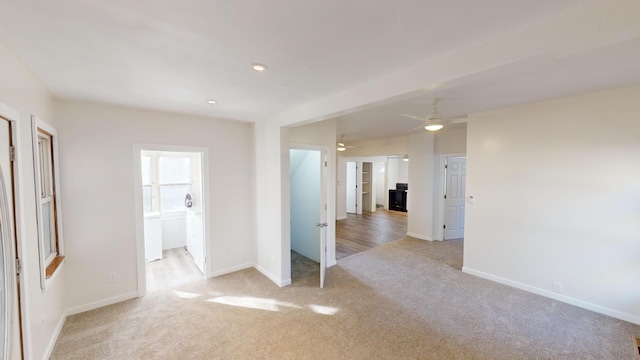 spare room featuring light colored carpet and ceiling fan