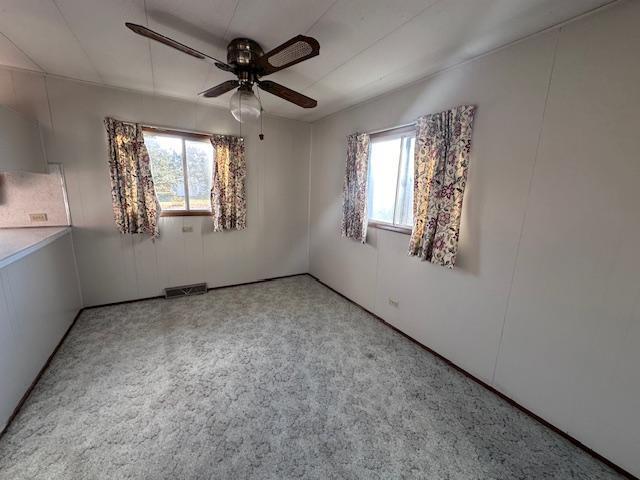 spare room featuring ceiling fan and light colored carpet