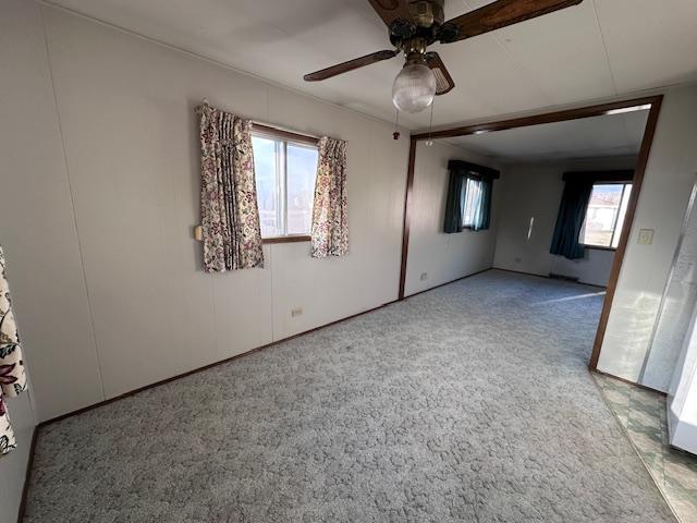 spare room featuring light carpet and ceiling fan