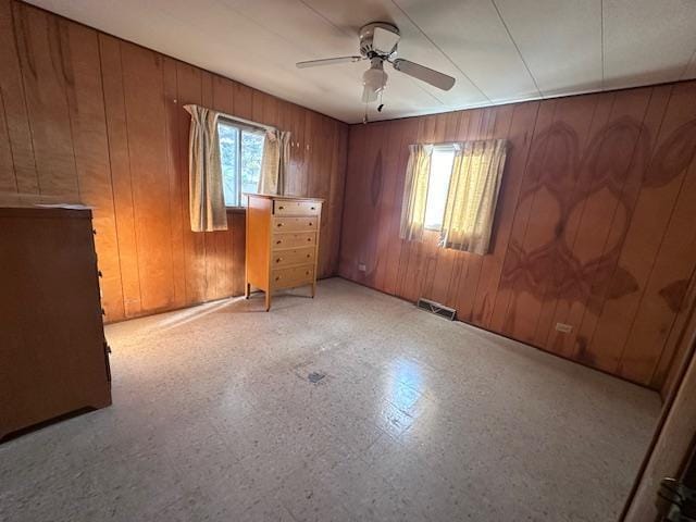 spare room featuring wood walls and ceiling fan