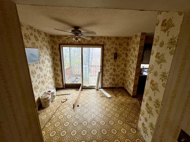 interior space with a textured ceiling and ceiling fan