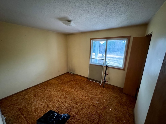 spare room featuring carpet and a textured ceiling