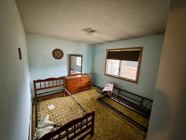 bedroom featuring a textured ceiling and carpet flooring