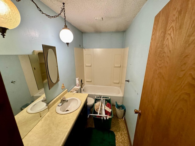 bathroom with washtub / shower combination, vanity, and a textured ceiling