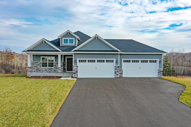 craftsman-style house with covered porch, a garage, and a front yard