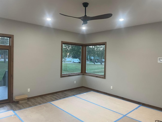 empty room with ceiling fan and hardwood / wood-style floors