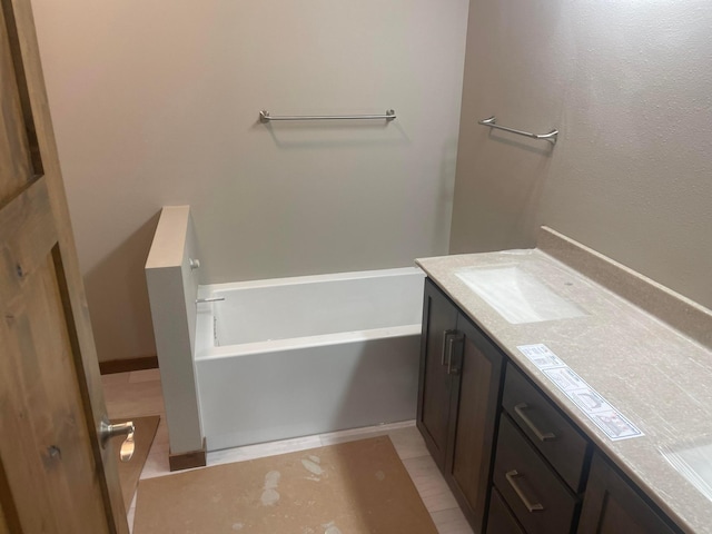 bathroom featuring vanity, tile patterned flooring, and a bathtub