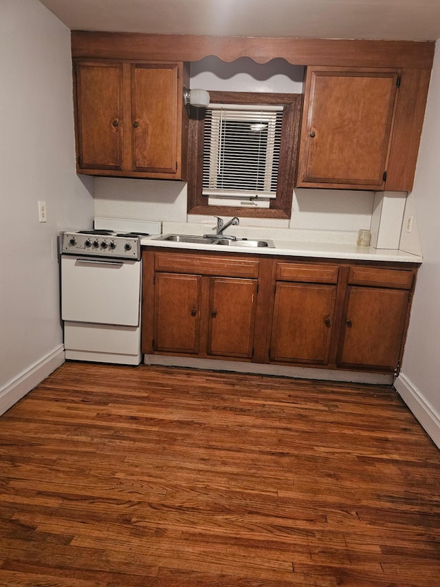 kitchen with white range oven, sink, and dark wood-type flooring