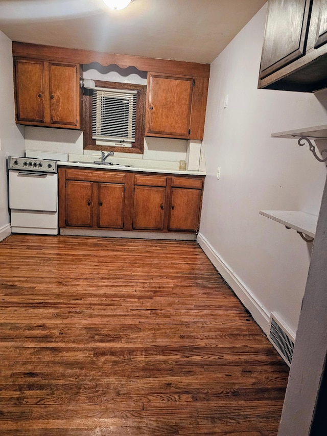 kitchen with sink, dark hardwood / wood-style floors, and white stove