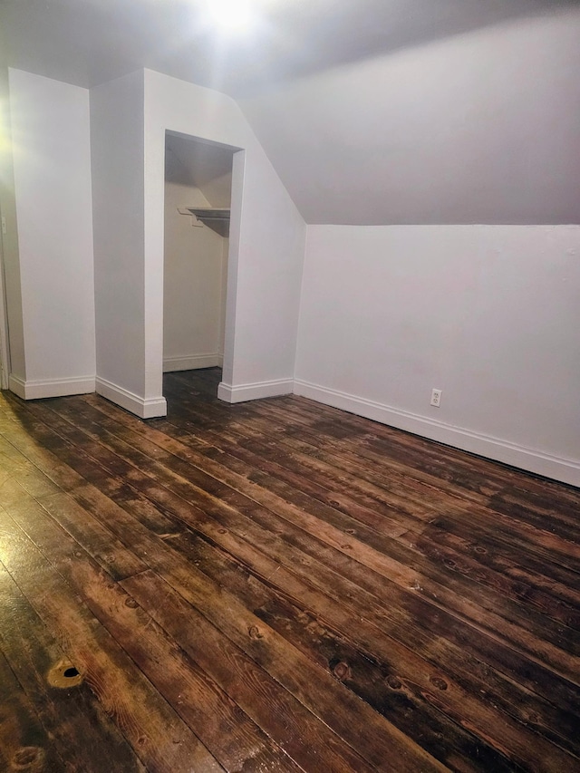 bonus room with dark hardwood / wood-style flooring and lofted ceiling