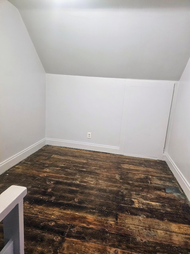 bonus room with dark hardwood / wood-style floors and vaulted ceiling