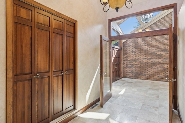6517 Crackleberry Trl, Woodbury, MN 55129 - entryway with brick wall and a chandelier