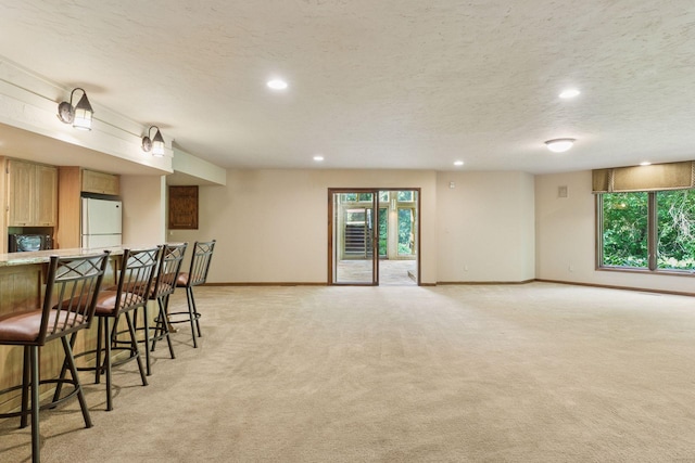6517 Crackleberry Trl, Woodbury, MN 55129 - kitchen featuring freestanding refrigerator, light colored carpet, a kitchen breakfast bar, plenty of natural light, and recessed lighting