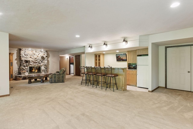 6517 Crackleberry Trl, Woodbury, MN 55129 - kitchen with freestanding refrigerator, light carpet, a breakfast bar, a stone fireplace, and recessed lighting