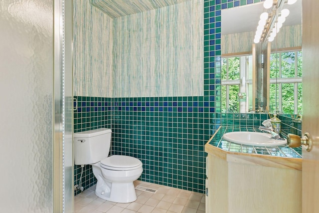 6517 Crackleberry Trl, Woodbury, MN 55129 - bathroom featuring tile patterned floors, tile walls, vanity, wallpapered walls, and a wainscoted wall