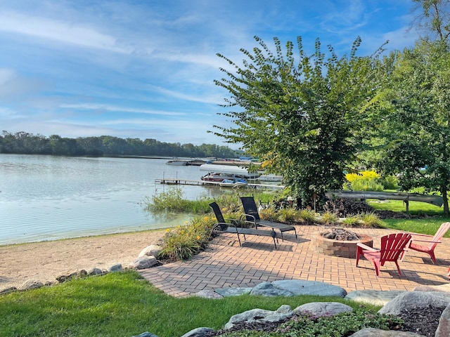 view of patio with a fire pit, a boat dock, and a water view