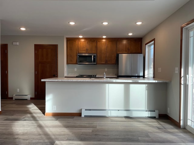 kitchen featuring a healthy amount of sunlight, stainless steel appliances, and a baseboard radiator