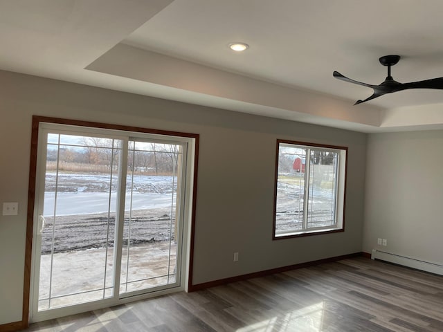 unfurnished room featuring a wealth of natural light, ceiling fan, and wood-type flooring