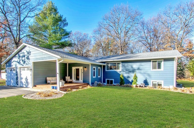 view of front of home with a front yard, a garage, and aphalt driveway